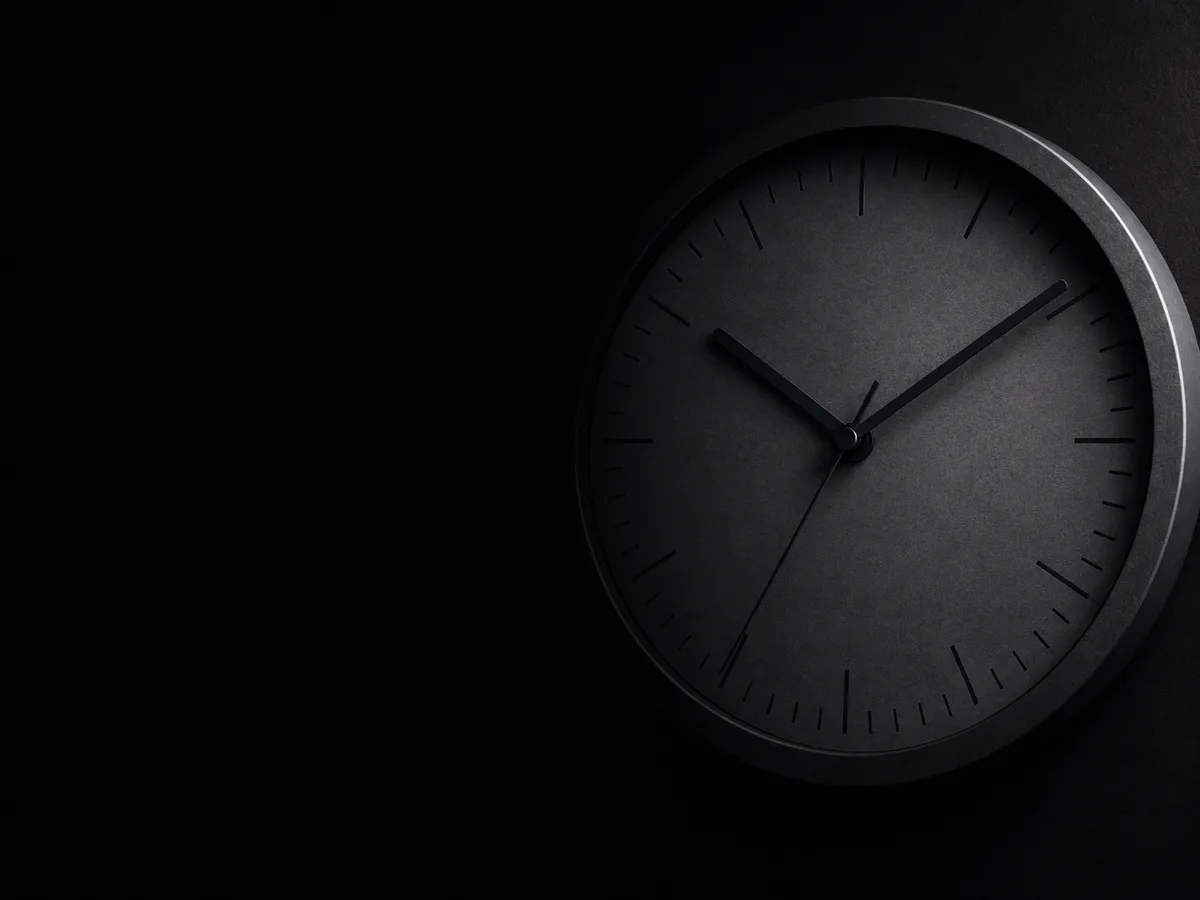 A dark clock, half in shadow